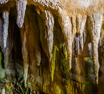 石笋岩湿的悬在洞穴顶上地底石坑背景的岩浆状石块图片