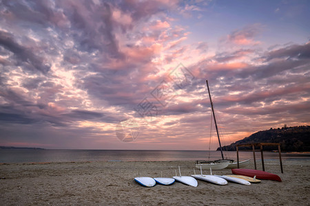 日出日落时分海滩上摆放的冲浪板图片