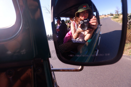 女在旅行途中用汽车侧镜反射时自拍的模糊画面美丽的微笑人们图片