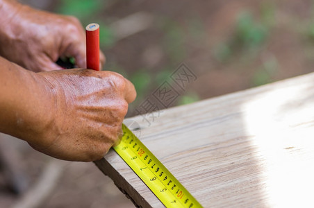工程宽度作场所计量的木匠用铅笔和手工测量胶带采用图片