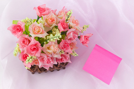 粉红背景的织物木篮子中玫瑰卡片花抽象图片