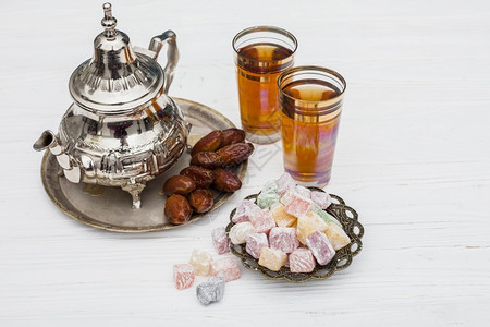 黄色的阿拉伯枣果配土耳其软糖茶壶沙漠背景图片