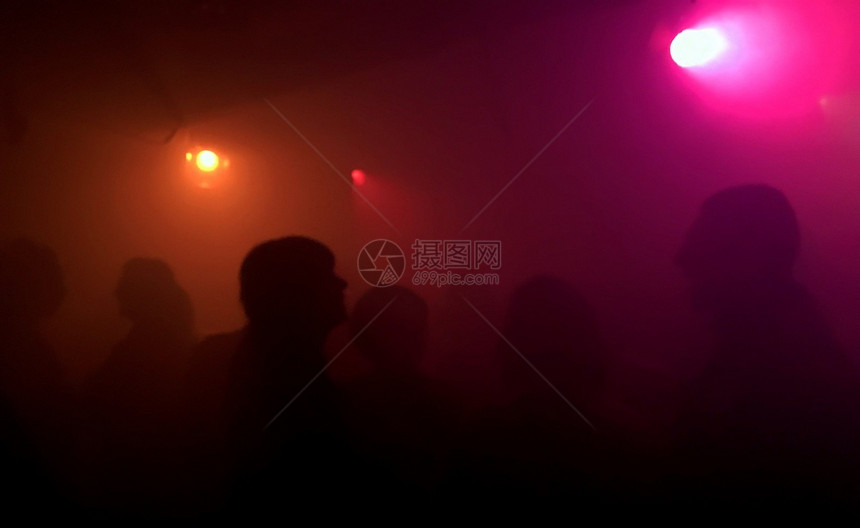 在阿姆斯特丹的一家俱乐部中人们在红光下跳舞和抽烟的休眠曲火焰剪影太阳图片