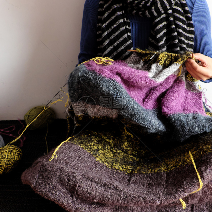 年轻的女士自制亚洲妇坐在家庭地板上冬季温暖时把羊毛毯编织起来是休闲活动的爱好以制作手工的礼品一天从前视看的妇女手工作照片图片