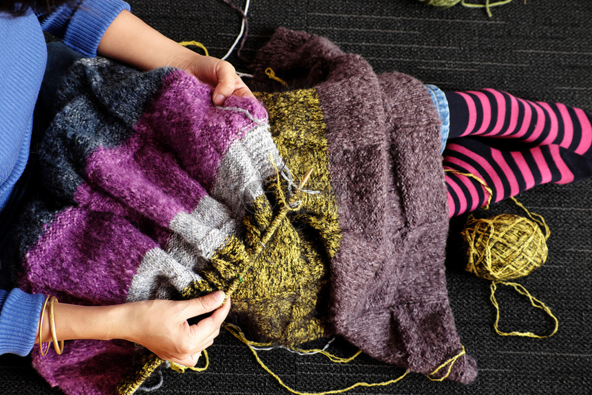 在职的亚洲妇女坐在家庭地板上冬季温暖时把羊毛毯编织为家用是休闲活动的爱好以制作手工的礼品照片显示一天从头到尾看的妇女手工作房间自图片