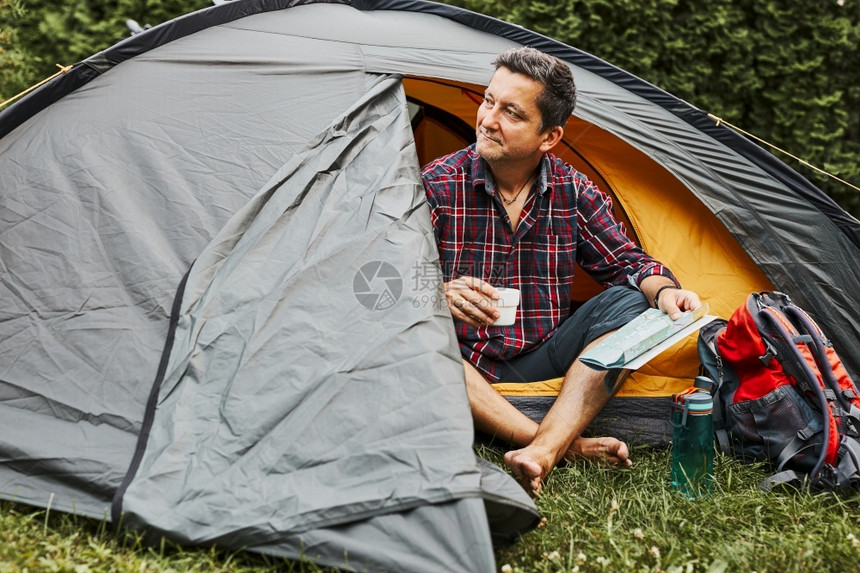自由暑假期间男子在露营帐篷中放松图片