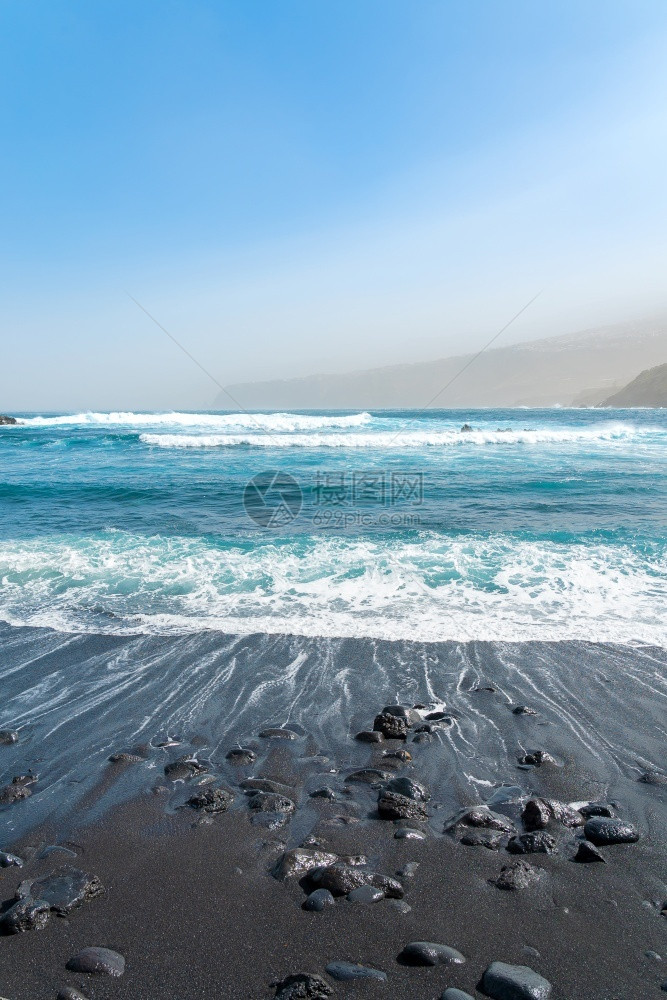 海滨黑沙滩与岩石海浪图片