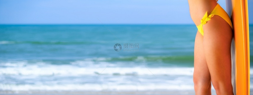 海滩皮肤景观身穿黄色比基尼的漂亮女身体站立和海背景共同空间设计网条横幅图片