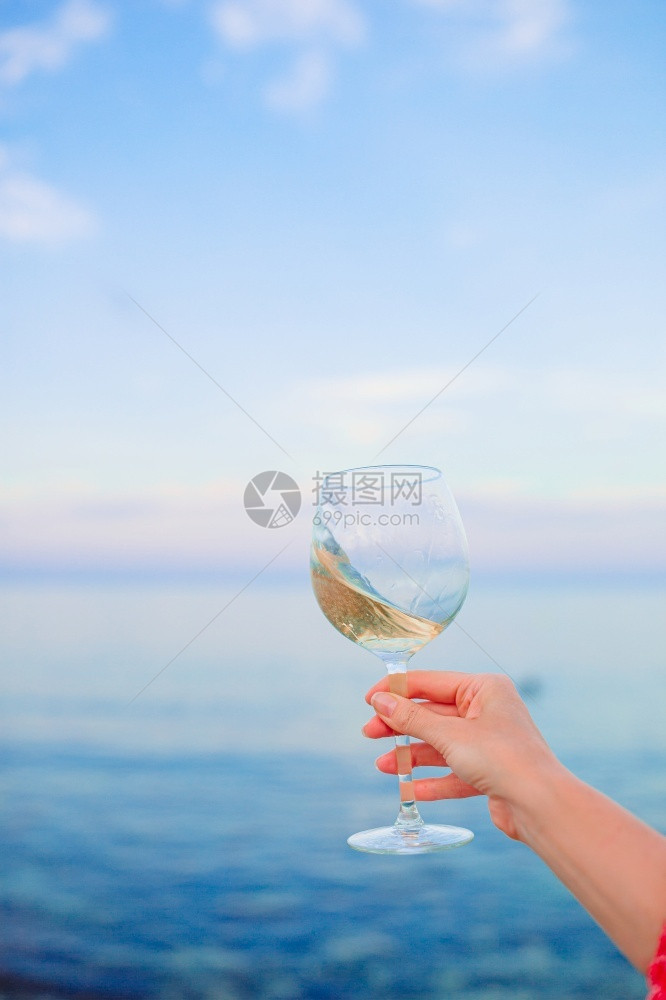 天空象征在日落的热带海滩上喝杯白葡萄酒在热带海滩上喝杯白葡萄酒夏天图片