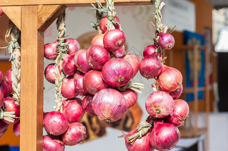 纳达林栽培的意大利在农民市场销售的红洋葱条纹编织球根状背景