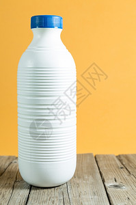 巴氏灭菌塑料带有颜色背景的桌上牛奶瓶有机农场背景