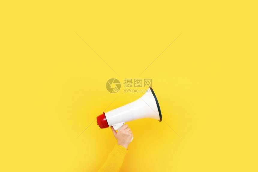 在黄色背景广告概念上手持的扩音器说话颜色宣布图片