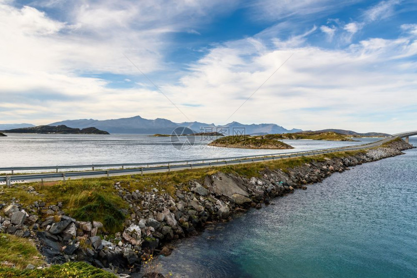 蓝色天空沿海面的阿拉法特公路挪威湾有选择重点美丽岩石云图片