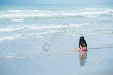 浪上玩沙子的小女孩图片