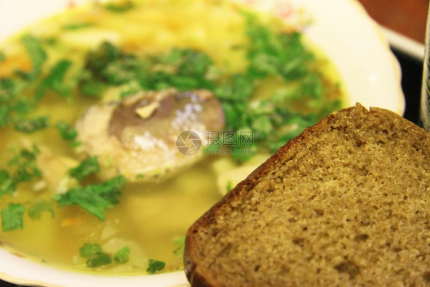土豆餐厅白碗中美味的热鱼汤配有草药和黑面包前景辛辣的图片