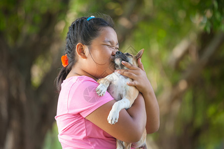 动物美丽的小亚洲女孩和狗在花园的里人们图片