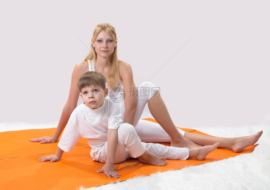 一个美丽的年轻母亲和儿子一起做瑜伽家女士头发图片