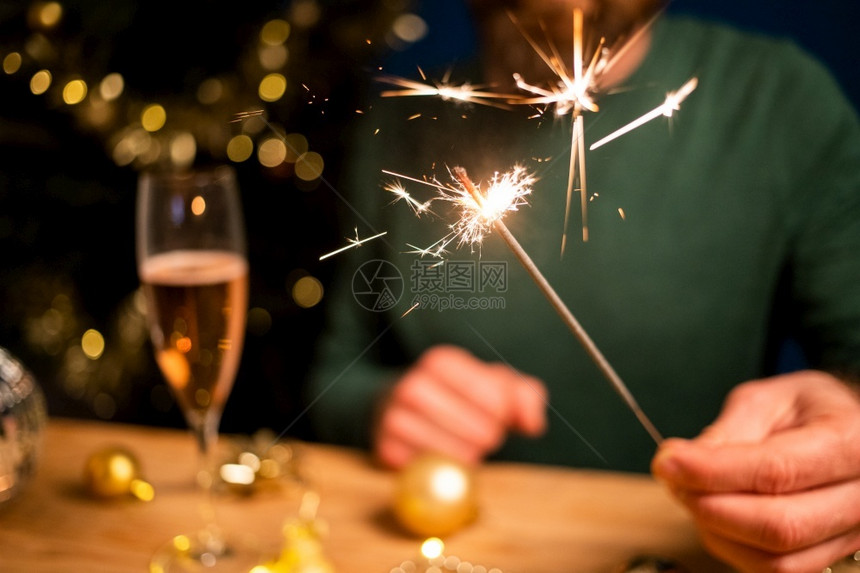 女新的男人拿着火花和香槟杯新年晚会乐趣图片