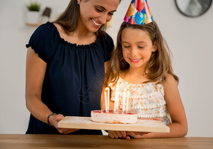 幸福在厨房中拍到母亲和女儿的一张照片庆祝女儿节生日孩蜡烛图片