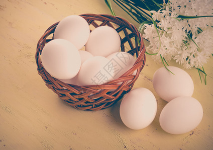 生复活节带鲜鸡蛋的篮子在木桌上配花胆固醇图片