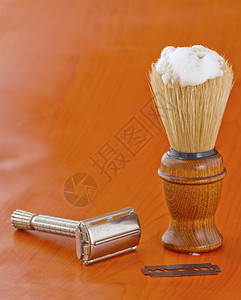 奶油木制的在一把用柄刮胡刀的旧剃旁边用木柄剃须的高级古老刷子男背景图片