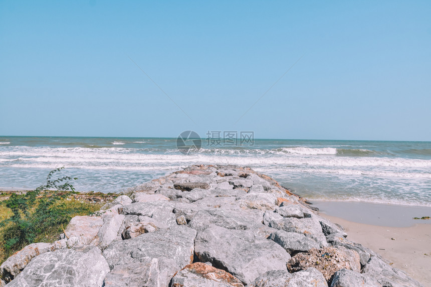 粉色的地平线海景滩上的岩石场景图片