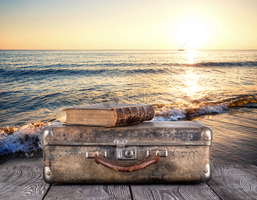 警报老的旧手提箱上面有关于木板对海的书籍时间旅行的概念旧手提箱上面有关于木板对海的书籍图片