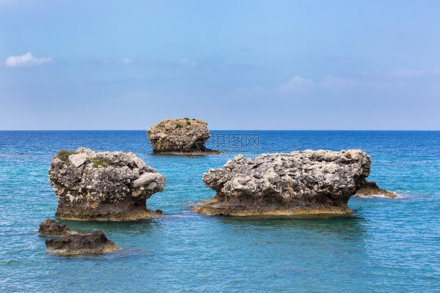 季节夏天空在蓝色的希腊海中上有三块不同的岩石图片