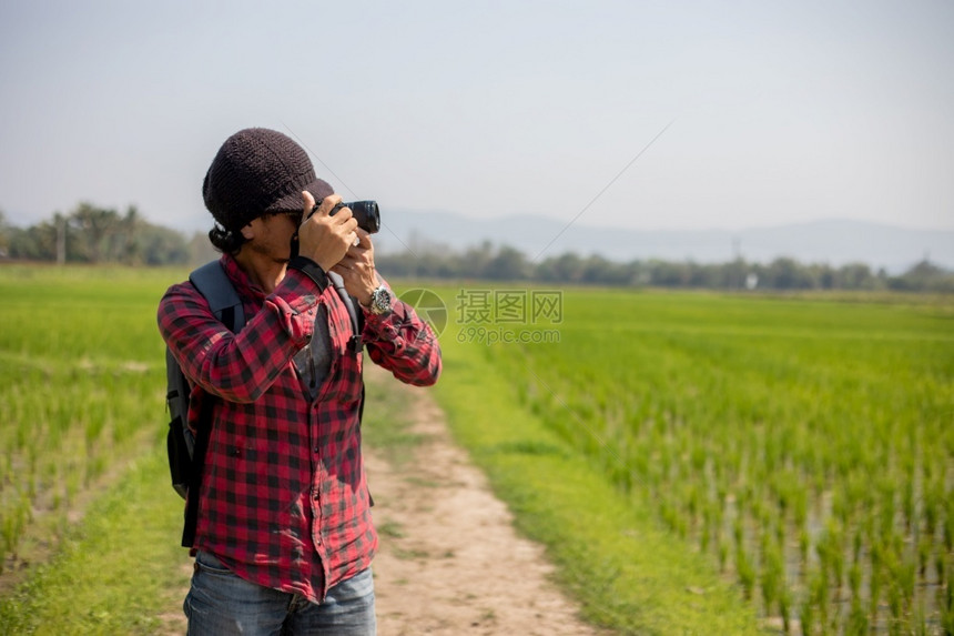 技术亚洲男子旅游者正在使用照相机拍摄风景和山地休闲时间的摄影照片以进行假日概念旅绿色男图片
