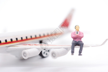 航班坐在白色背景的飞机翼上微型商以白人为背景地球旅游图片