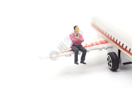 乘客运输坐在白色背景的飞机翼上微型商以白人为背景数字图片