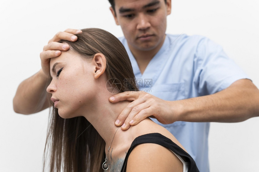 理疗师按摩妇女脖子医疗的病人指压图片