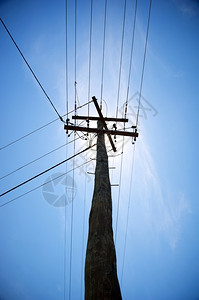 电气城市在后面抬头仰望着一条有阳光的电线紧靠在太阳后面图片