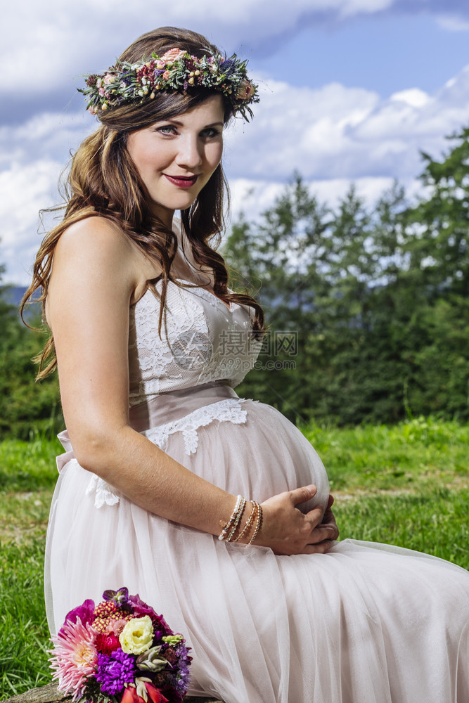 女一种华丽的照片来自一位美丽的怀孕新娘坐在板凳上等待仪式开始的照片她当时正在等待仪式的开始图片