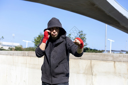 拳击手穿套公园户外运动健壮青年员进行拳击练习图片