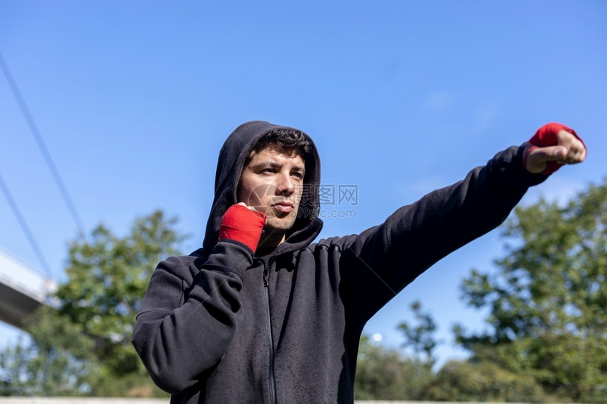 身体的拳头成人公园户外运动健壮青年员进行拳击练习图片