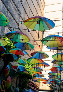 挂在最上街道装饰处的彩色雨伞黄抛光彩虹图片