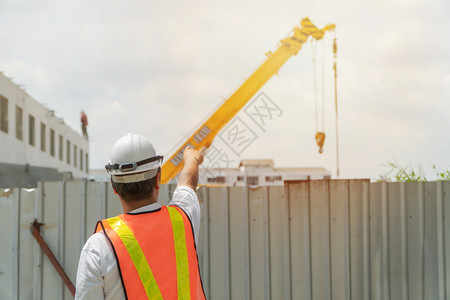 工程戴白色安全帽站在施工现场前控制和检查施工精度的概念建筑学设者准确图片