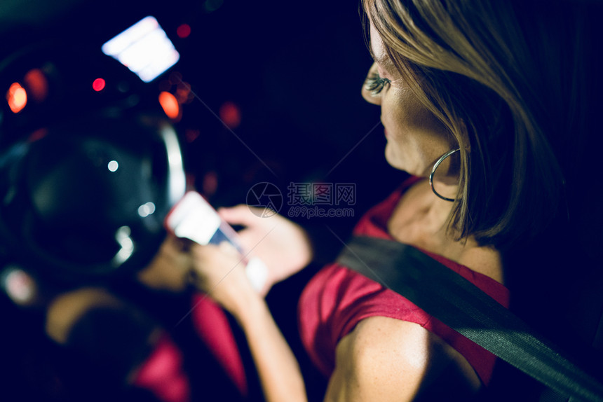 里面白种人旅行女驾驶员坐在汽车中的上用手机打电话发送信号息妇女驾驶员使用移动电话图片