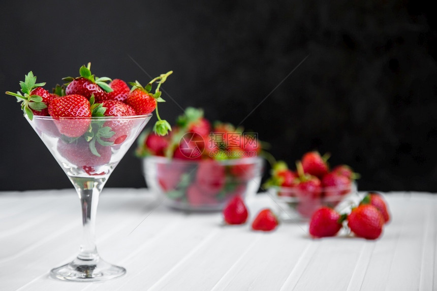 生的木制高架白色背景碗中的新鲜草莓顶部观点白色背景中碗的新鲜草莓图片