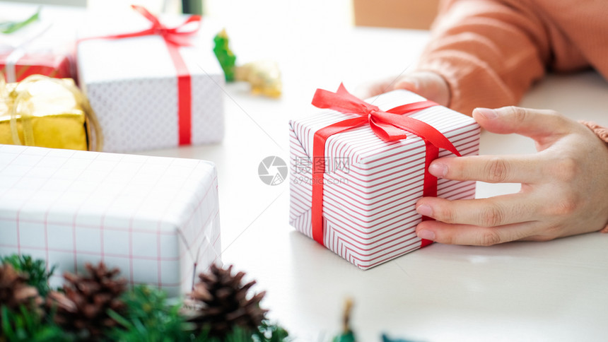 给予接收丝带紧女手拿着礼物盒圣诞节生日和新年快乐概念的礼物盒图片