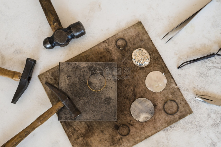 在皮革背景上使用珠宝首饰工作场所具的锤子AvilTop视图金匠手工制作的木图片