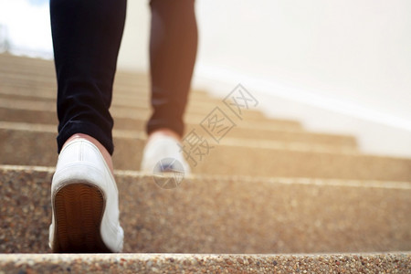 成功现代的街道在办公大楼中一名妇女走上楼梯图片
