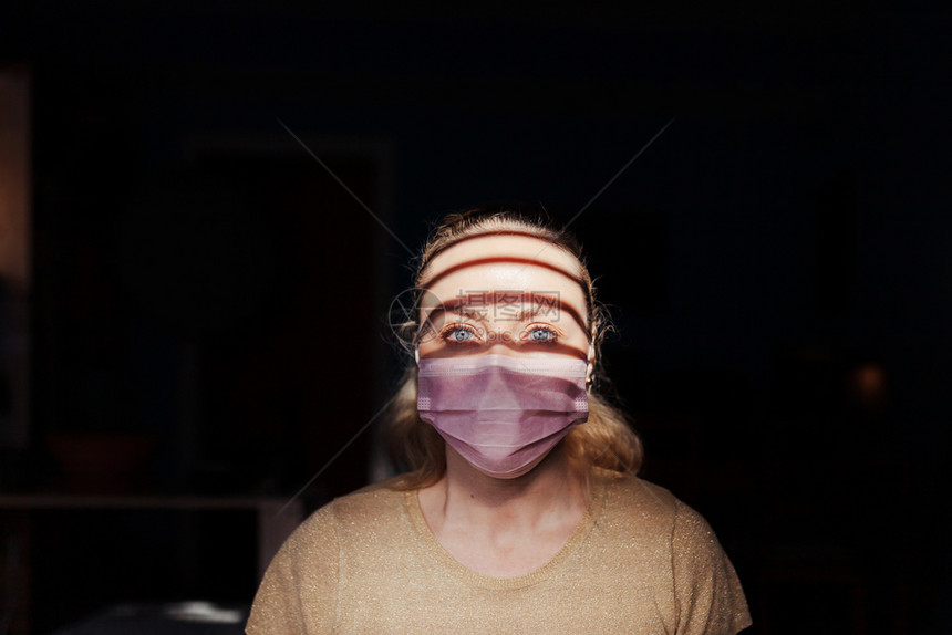 感染发烧在家中隔离的妇女佩戴着口罩图片