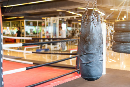 拳头黑袋挂在抽象摘要中其模糊了运动设备为Gym模糊背景的体育锻炼设备操健身和俱乐部的分心拳击室内健身和俱乐部斗争努力背景图片