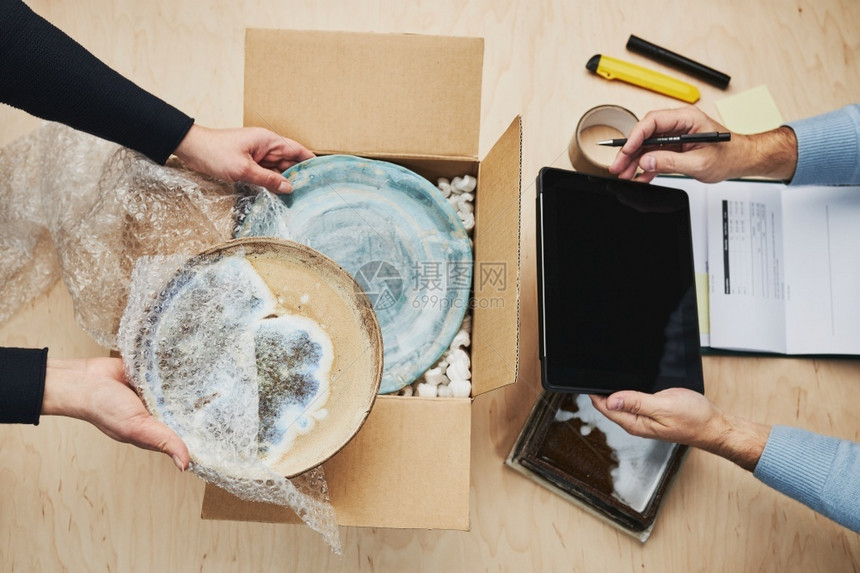 企业主在线包装上订单向客户发货准备网上商店的装有陶瓷板制品的包裹盒零售所有者陶瓷制品图片