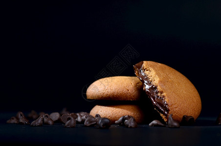 诱人的巧克力奶油饼干棕色巧克力黑色背景奶油馅好吃黑色的图片