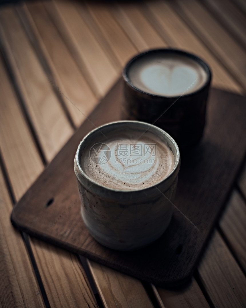 可口咖啡因文化有选择焦点杯在木制桌上有热拿铁艺术咖啡重点是在木制上有热拿铁艺术咖啡的白泡沫杯图片