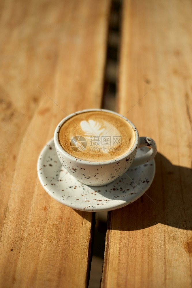 在木制桌上有选择焦点杯热拿铁艺术咖啡重点是白泡沫热拿铁木制咖啡可选择的豆子光滑图片