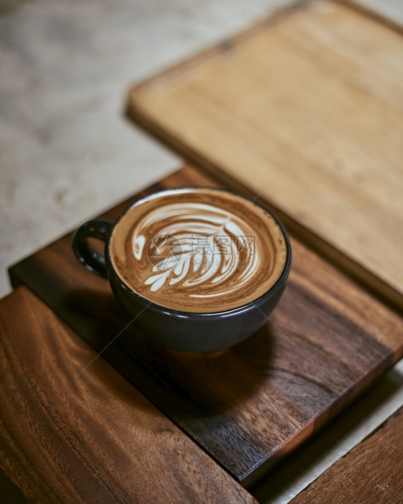 早餐木制桌上的热拿铁艺术咖啡重点放在白泡沫上木制桌的热拿铁艺术咖啡因卡布奇诺图片